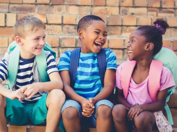 Three kids smiling together after children's dentistry visit