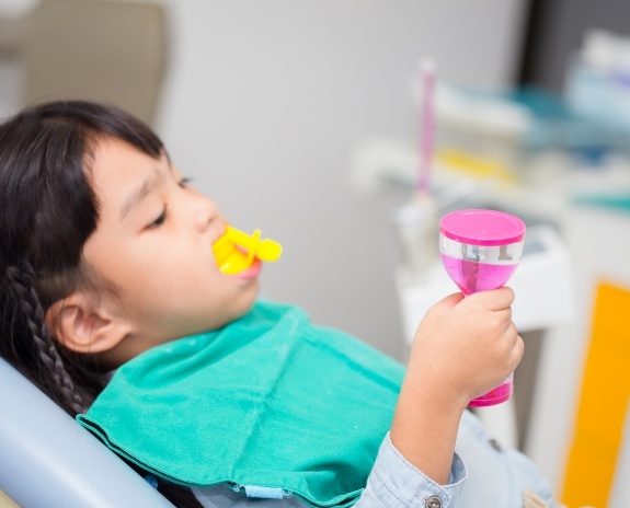 Child receiving silver diamine fluoride treatment