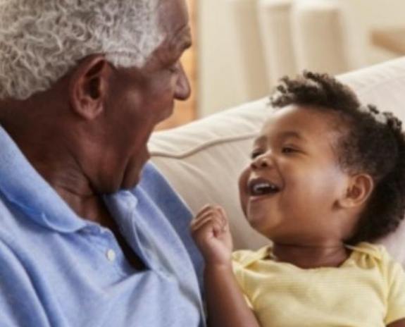 Grandfather enjoying benefits of dental implants spending time with grandchild