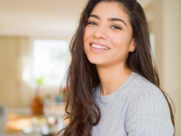 Woman with veneers in Cherry Hill smiling at home