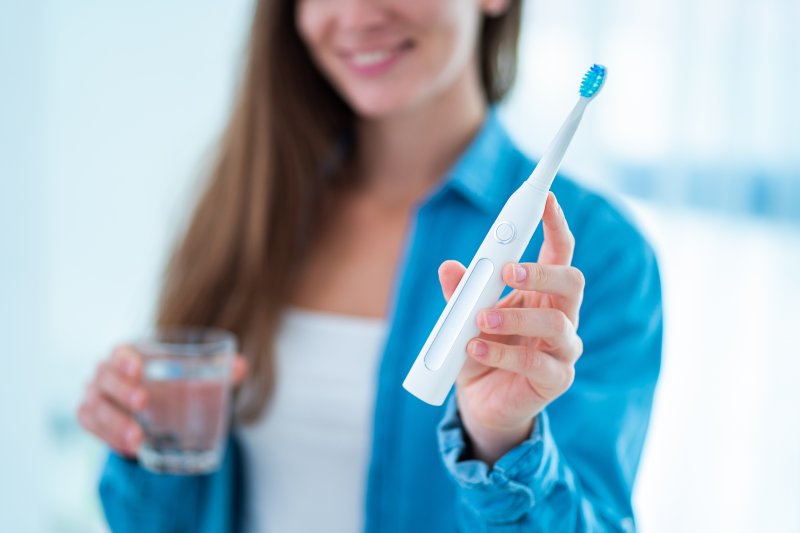 a woman holding an electric toothbrush in Cherry Hill