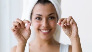 Woman holding a strand of dental floss.